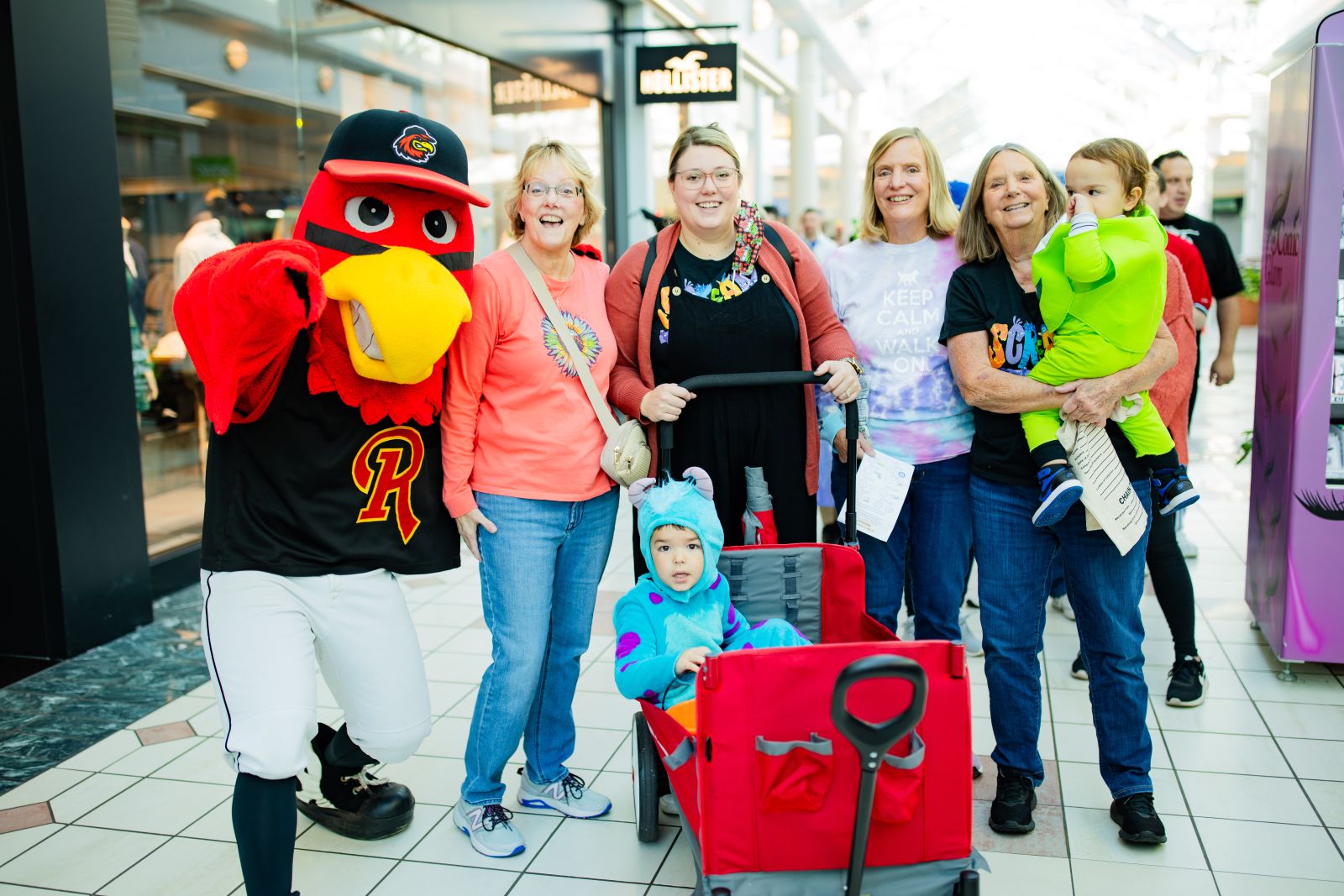 The mascot Spikes from the Rochester Red Wings standing with a family of 4 women